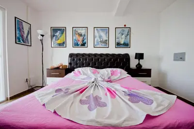a bed with a pink and white dress on it at Apartments Dora in Dobra Voda