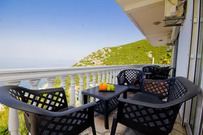 a porch with chairs and a table with a fruit on it at Apartments Dora in Dobra Voda