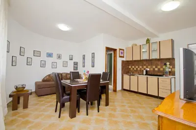 a kitchen and dining room with a table and chairs at Apartments Dora in Dobra Voda