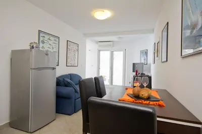 a kitchen with a dining table and a refrigerator at Apartments Dora in Dobra Voda