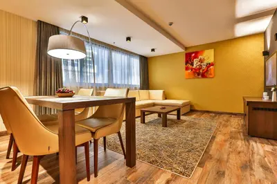 a living room with a table and chairs and a couch at Hotel Zeta in Budva