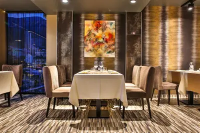 a dining room with tables and chairs and a painting at Hotel Zeta in Budva