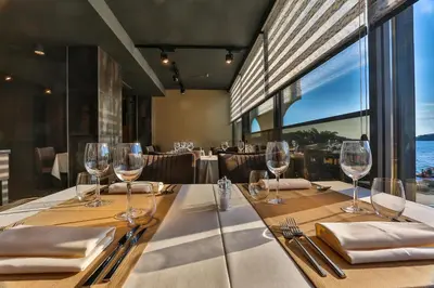 a dining room with a table with wine glasses at Hotel Zeta in Budva