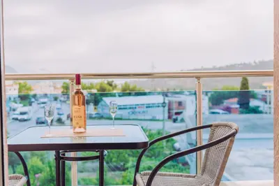 a bottle of wine sitting on a table with two glasses at Apartments Krstovic in Sutomore