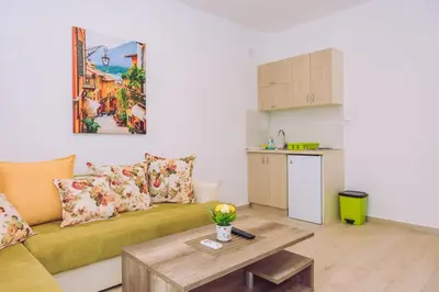 a living room with a green couch and a table at Apartments Krstovic in Sutomore