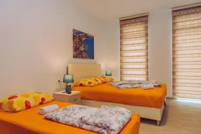 two twin beds in a room with windows at Apartments Krstovic in Sutomore