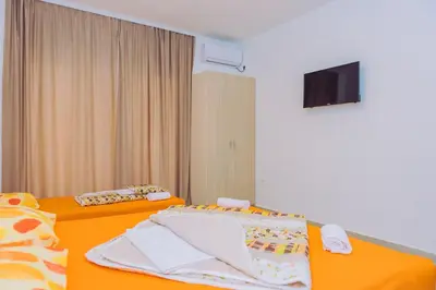 a hotel room with two beds and a flat screen tv at Apartments Krstovic in Sutomore