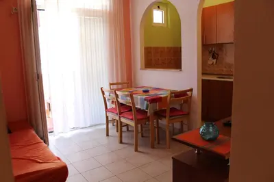 a kitchen and dining room with a table and chairs at Apartman Bošković in Budva