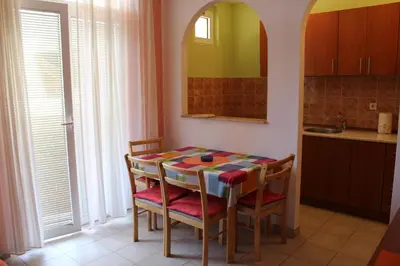 a kitchen with a table and chairs in a room at Apartman Bošković in Budva