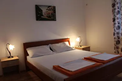 a bedroom with a bed with two lamps on both sides at Apartman Bošković in Budva