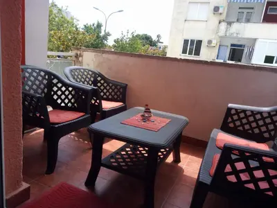 a small table and chairs on a balcony with a window at Apartman Bošković in Budva