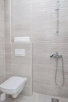 a white bathroom with a toilet and a shower at Apartments Tina in Utjeha