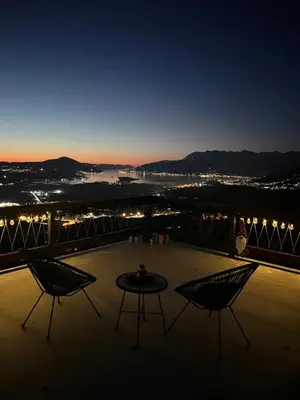 a table and two chairs on a balcony at night at Villa Gorazda in Kotor
