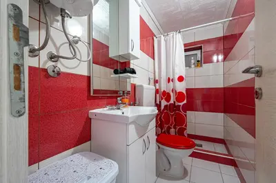 a red and white bathroom with a toilet and a sink at Villa Gorazda in Kotor