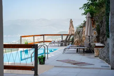 a pool with chairs and umbrellas next to at Villa Gorazda in Kotor