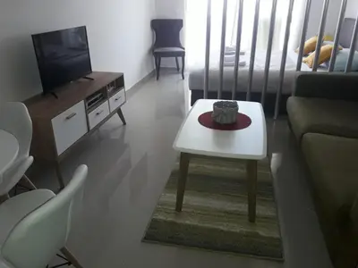 a living room with a couch and a table and a tv at Apartman Nina in Bar