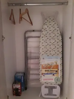 a book shelf with a surfboard in a closet at Apartman Nina in Bar