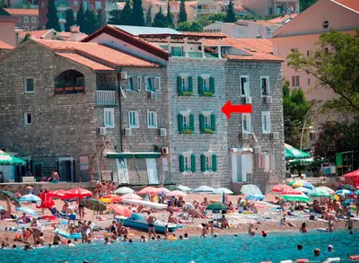 a group of people on a beach with a building at Piazza Apartments 1 in Petrovac na Moru
