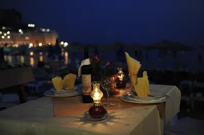 a table with a bottle of wine and glasses at Hotel Obala in Budva