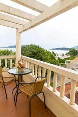 a patio with a table and chairs on a balcony at Hotel Obala in Budva