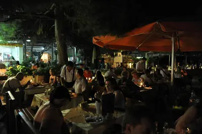 a group of people sitting at tables in a restaurant at Hotel Obala in Budva