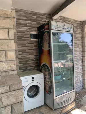 a washer and a bottle of beer next to a washing machine at Andolly Apartments in Bar