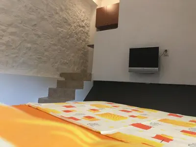 a bedroom with a bed and a tv on the wall at Apartmani Pavicevic in Podgorica