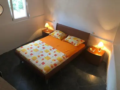 a bedroom with a bed with two lamps on two tables at Apartmani Pavicevic in Podgorica