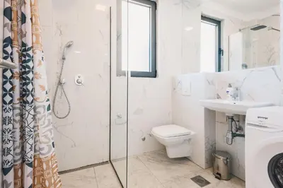 a bathroom with a shower and a toilet and a sink at Apartment L'ideal in Ulcinj