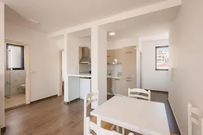 a kitchen and dining room with a white table and chairs at Apartment L'ideal in Ulcinj