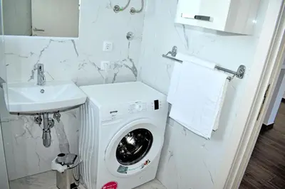 a bathroom with a washing machine and a sink at Apartment L'ideal in Ulcinj