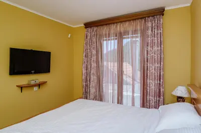 a bedroom with a bed and a window with a television at RUSTIC HOUSE LEKOVIĆ in Virpazar