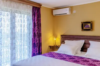 a bedroom with a bed and a window with purple curtains at RUSTIC HOUSE LEKOVIĆ in Virpazar