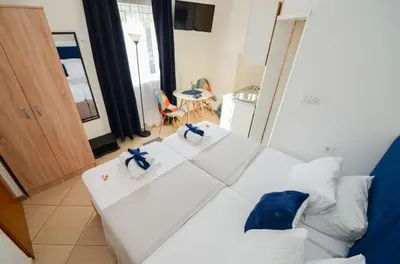 a white bed in a room with a table at Tea apartments in Kotor