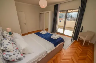 a bedroom with a bed and a window and a chair at Tea apartments in Kotor