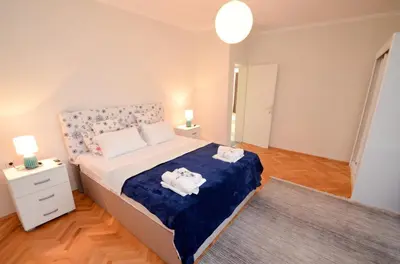 a bedroom with a bed with a blue blanket at Tea apartments in Kotor
