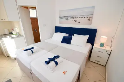 two beds in a room with white and blue at Tea apartments in Kotor