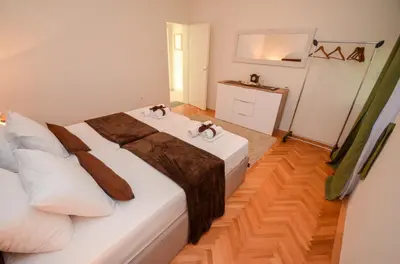a bedroom with a bed with white sheets and brown blankets at Tea apartments in Kotor