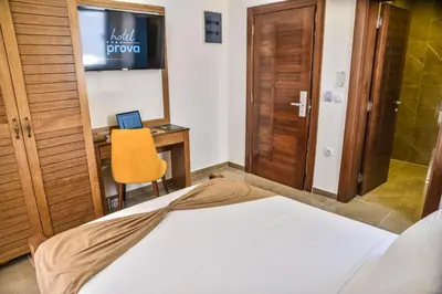 a bedroom with a bed and a desk with a laptop at Hotel Prova in Ulcinj