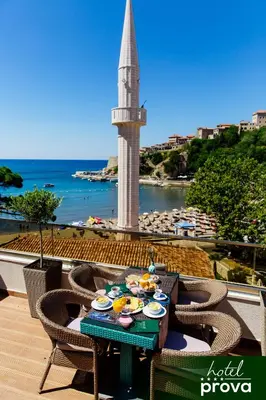 a table with food on top of a balcony with a tower at Hotel Prova in Ulcinj