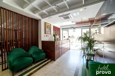 a lobby with green chairs and a reception desk at Hotel Prova in Ulcinj