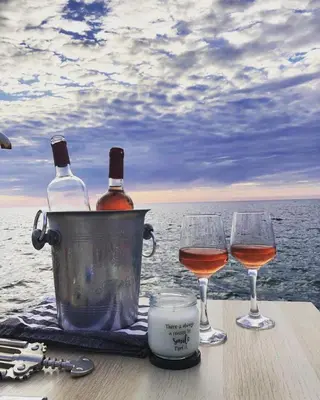 a table with two wine glasses and a bucket with wine bottles at Apartments Apartmani Bojana in Utjeha