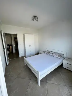 a bedroom with a white bed in a room at Apartments Apartmani Bojana in Utjeha