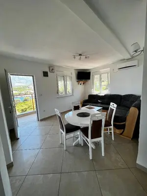 a living room with a table and chairs and a couch at Apartments Apartmani Bojana in Utjeha