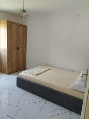 a bedroom with a bed and a wooden cabinet at Apartmani Srdanovic in Tivat