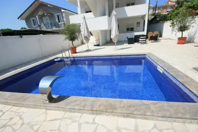 a swimming pool with blue water in a house at Apartmani Srdanovic in Tivat