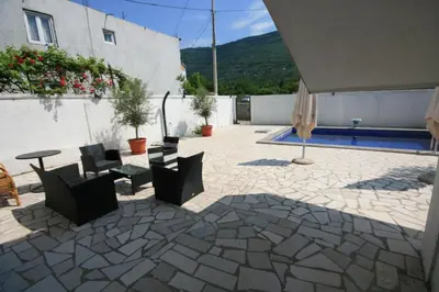 a patio with chairs and a table and a building at Apartmani Srdanovic in Tivat