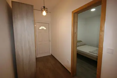 a hallway with a door and a bedroom with a bed at Apartmani Srdanovic in Tivat