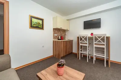 a small living room with a table and a kitchen at Mika's Seaview Apartments in Bar