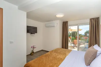a hotel room with a bed and a balcony at Mika's Seaview Apartments in Bar